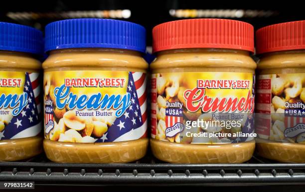 March 2018, Germany, Hamburg: Peanut butter jars from the USA are stacked on a shelf in a supermarket. The President of the European Commission,...