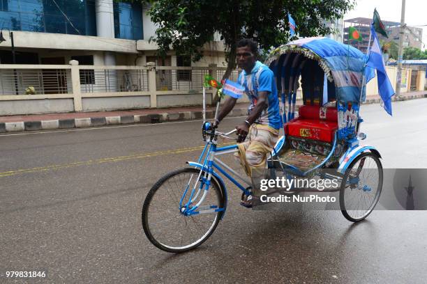 Bangladeshi Rickshaw driver fan of Argentina football team painted on his rickshaw the shape of the flag of the Argentine driving rickshaw around the...