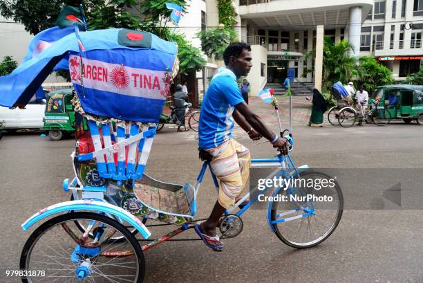 Bangladeshi Rickshaw driver fan of Argentina football team painted on his rickshaw the shape of the flag of the Argentine driving rickshaw around the...