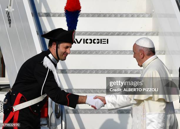 Pope Francis shakes hands with a Carabiniere as he prepares to fly from the Fiumicino airport on June 21 to Geneva for a one day pastoral trip.