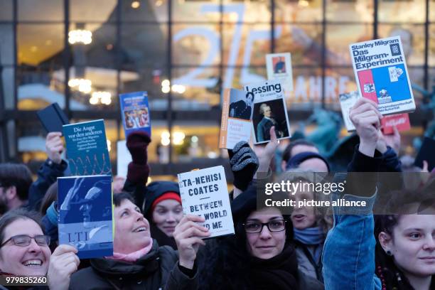 March 2018, Germany, Leipzig: Demonstrators hold books in their hands as they rally on the Augustusplatz square in central Leipzig. Around 200 people...