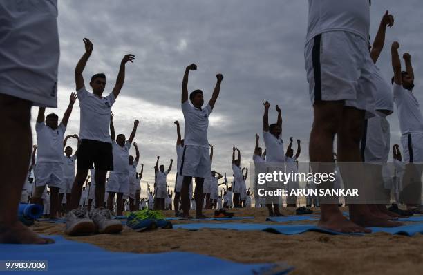 Indian Naval Cadets take part in a yoga session to mark International Yoga Day in Chennai on June 21, 2018. - Downward-facing dogs, cobras and...