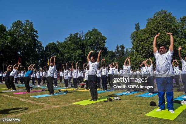 Indian Army personnel and school children take part in a yoga session on International Yoga Day in Srinagar, Indian administered Kashmir. Hundreds of...