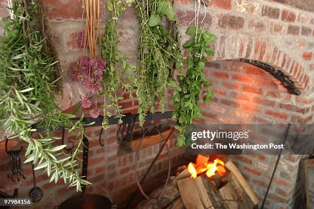 Kitchen- New colonial kitchenn display in the Carriage House of the Montpelier House in Laurel. Fresh herbs hanging over the fireplace. By James M...