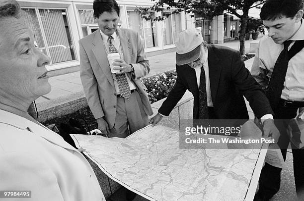 In the wake of multiple terrorist attacks on the U.S. Pictured, federal employees, evacuated from the New Executive Office Building, consult a map to...