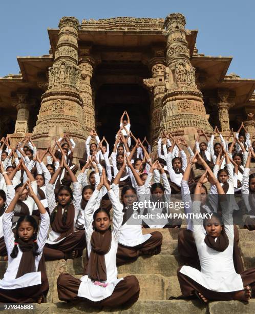 Indian school students take part in a yoga session to mark International Yoga Day at the Sun Temple in Modhera, near Mahesana town some 100km from...