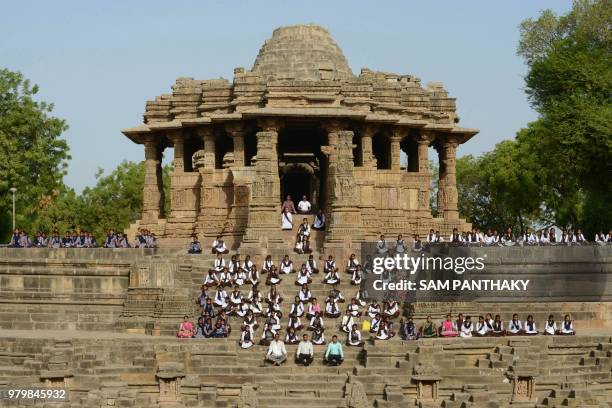 Indian school students take part in a yoga session to mark International Yoga Day at the Sun Temple in Modhera, near Mahesana town some 100km from...