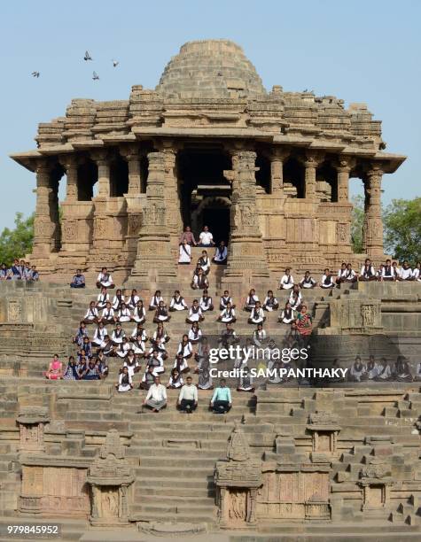 Indian school students take part in a yoga session to mark International Yoga Day at the Sun Temple in Modhera, near Mahesana town some 100km from...