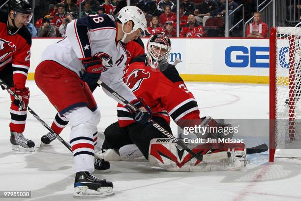 Martin Brodeur of the New Jersey Devils makes a pad save against RJ Umberger during the first period at the Prudential Center on March 23, 2010 in...