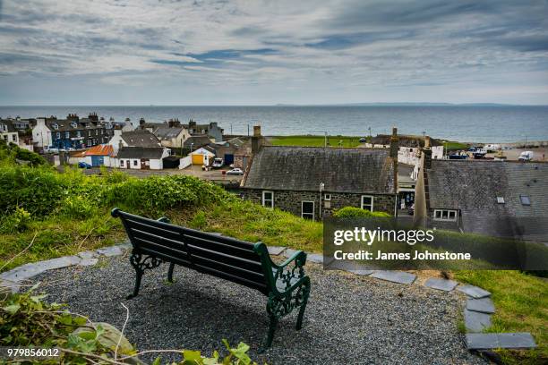 empty bench overlooking fishing village and port william, dumfries and galloway, scotland, uk - dumfries and galloway stock pictures, royalty-free photos & images