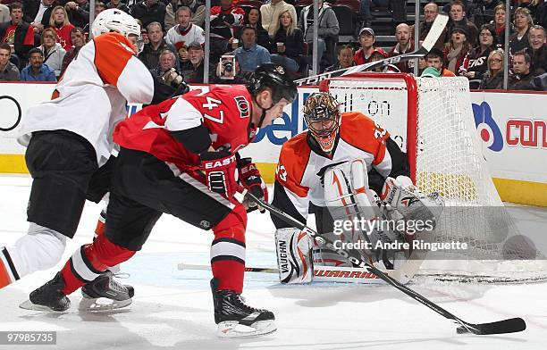 Zack Smith of the Ottawa Senators controls the puck and fights off a check as Brian Boucher of the Philadelphia Flyers guards his net at Scotiabank...