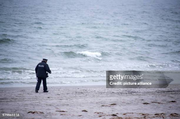 March 2018, Germany, Hiddensee: Island police officer Martina Dominik on duty despite the rain at the beach on the Baltic Sea island of Hiddensee....