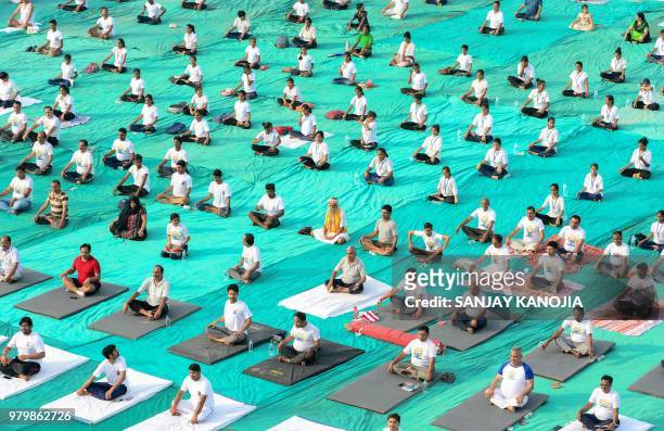 Indian yoga practitioners take part in a mass yoga session on International Yoga Day in Allahabad on June 21, 2018. - Downward-facing dogs, cobras...