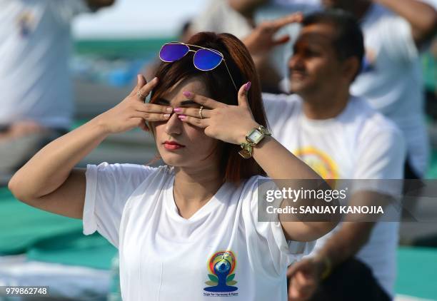 Indian yoga practitioners take part in a mass yoga session on International Yoga Day in Allahabad on June 21, 2018. - Downward-facing dogs, cobras...