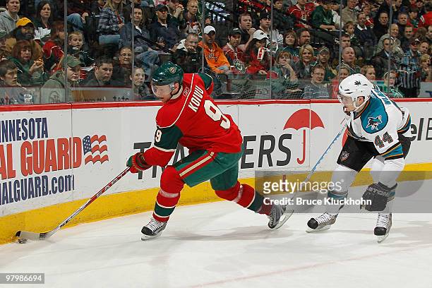 Mikko Koivu of the Minnesota Wild handles the puck near the boards while Marc-Edouard Vlasic of the San Jose Sharks defends during the game at the...