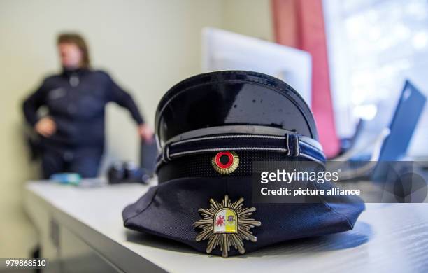 March 2018, Germany, Hiddensee: Island police officer Martina Dominik's cap lying on a table in the police station in the town of Vitte on the Baltic...
