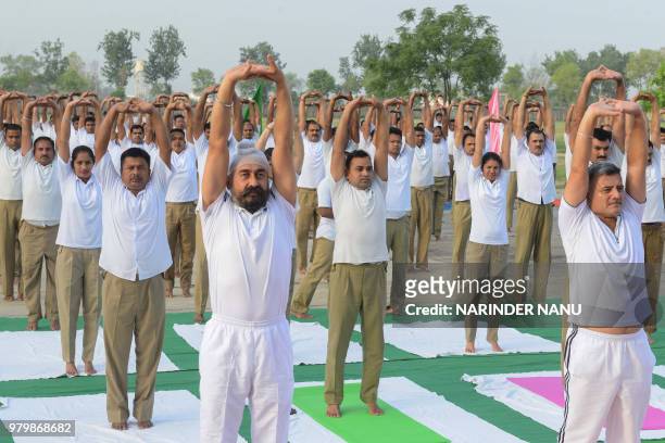 Indian Border Security Force personnel take part in a yoga session on International Yoga Day at BSF headquarters in Khasa on the outskirts of...