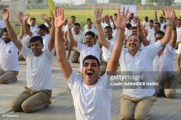 Indian Border Security Force personnel take part in a yoga session on International Yoga Day at BSF headquarters in Khasa on the outskirts of...