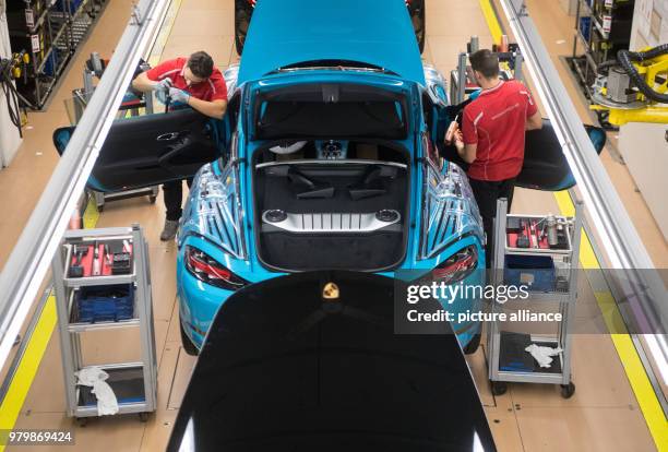 January 2018, Germany, Stuttgart: A worker fitting a Porsche 718 Cayman at the Porsche main factory. Photo: Marijan Murat/dpa