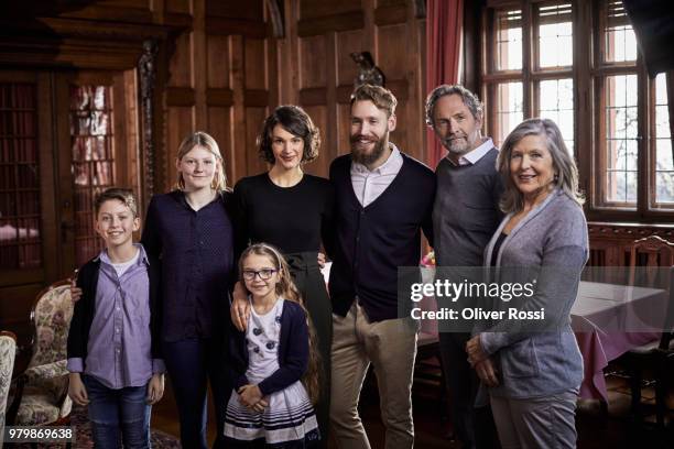 portrait of three generation family standing in a villa - families meeting inside stock pictures, royalty-free photos & images