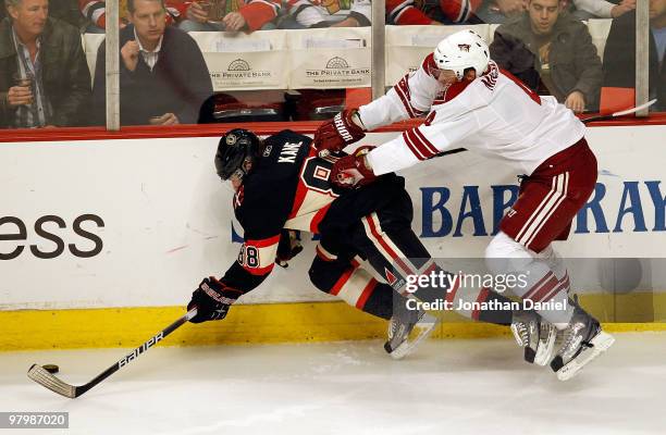 Patrick Kane of the Chicago Blackhawks is pushed to the ice by Zbynek Michalek of the Phoenix Coyotes at the United Center on March 23, 2010 in...