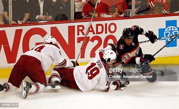 Taylor Pyatt and Shane Doan of the Phoenix Coyotes hit the ice after colliding with Dustin Byfuglien of the Chicago Blackhawks at the United Center...