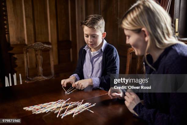 young woman and boy playing mikado together - mikado stock pictures, royalty-free photos & images