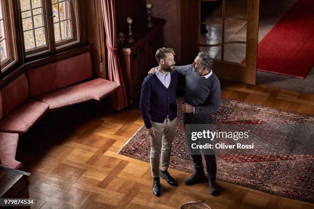 father and adult son in a villa talking - father and son discussion stock-fotos und bilder