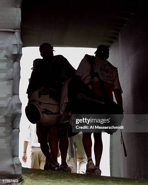 Tour caddies leave the 18th green tunnel after first-round play at the FedEx St. Jude Classic May 27, 2004 at the Tournament Players Club Southwind,...