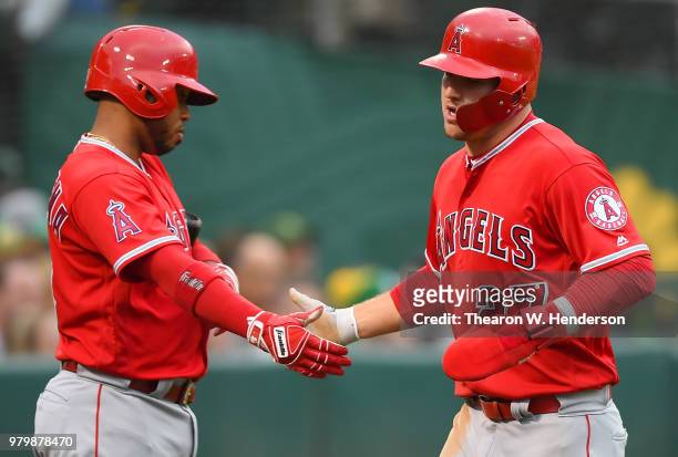 Mike Trout of the Los Angeles Angels of Anaheim is congratulated by Luis Valbuena after Trout scored against the Oakland Athletics in the top of the...