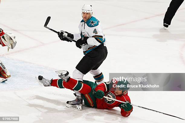 Cam Barker of the Minnesota Wild is knocked down while battling for position with Rob Blake of the San Jose Sharks during the game at the Xcel Energy...