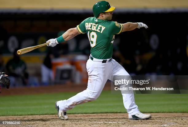 Josh Phegley of the Oakland Athletics bats against the Los Angeles Angels of Anaheim in the bottom of the seventh inning at the Oakland Alameda...