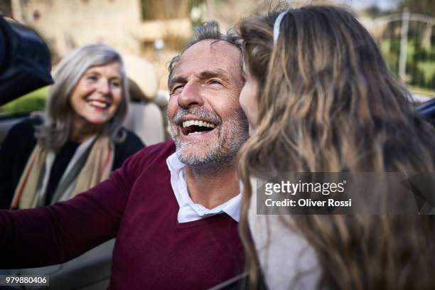 girl kissing laughing grandfather in convertible car - luxury family stock pictures, royalty-free photos & images