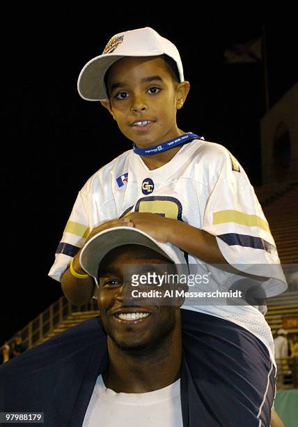 Georgia Tech running back P. J Daniel gives a piggy-back ride to Jett Modkins, the son of running backs coach Curtis Modkins, at the Champs Sports...