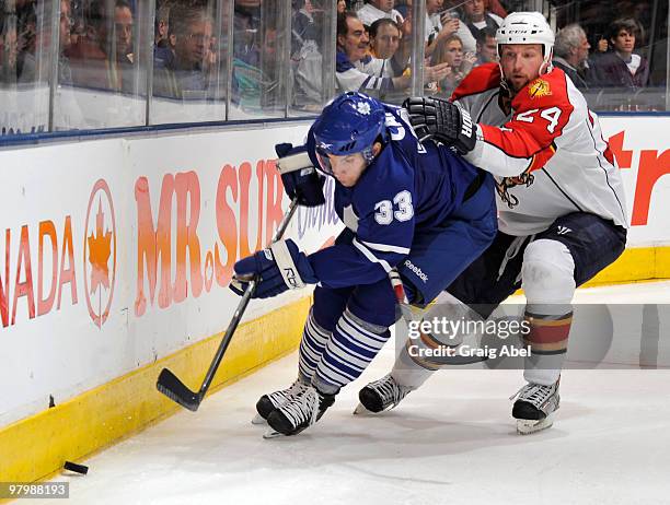 Luca Caputi of the Toronto Maple Leafs battles for the puck with Bryan McCabe of the Florida Panthers during game action March 23, 2010 at the Air...