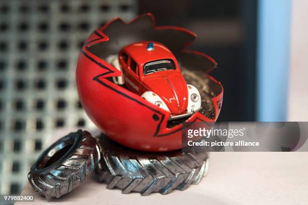 March 2018, Germany, Sonnenbuehl: A cut-open goose egg, which has been painted in acrylic, with a toy car inside it, by artist Magdalene Glasbrenner,...
