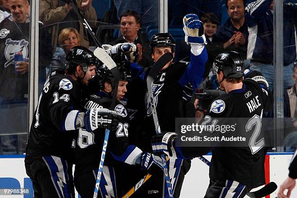 Martin St. Louis of the Tampa Bay Lightning is congratulated on his goal against the Carolina Hurricanes by teammates Andrej Meszaros, Vincent...