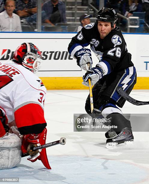 Martin St. Louis of the Tampa Bay Lightning scores an overtime-winning goal against Manny Legace of the Carolina Hurricanes at the St. Pete Times...