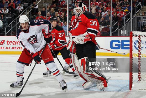 Martin Brodeur of the New Jersey Devils makes a save as Mike Blunden of the Columbus Blue Jackets looks for a rebound at the Prudential Center on...