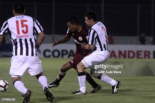 Peruvian Universitario de Lima footballer's Luis Ramirez vies for the ball with Adalberto Roman and Miguel Samudio of Paraguay?s Libertad during...