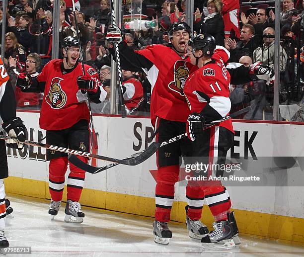 Daniel Alfredsson of the Ottawa Senators celebrates his third period goal against the Philadelphia Flyers with teammates Peter Regin and Chris...