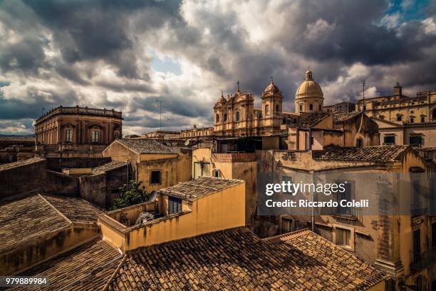old buildings and noto cathedral under moody sky, noto, sicily, italy - noto fotografías e imágenes de stock