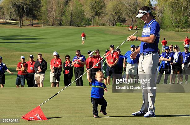 Justin Rose of England and the Lake Nona Team is amazed and his 13 month old son Leo enjoying playing with the flagstick at the at the 18th hole...