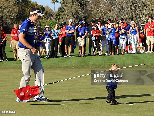 Justin Rose of England and the Lake Nona Team is amazed and his 13 month old son Leo enjoying playing with the flagstick at the at the 18th hole...
