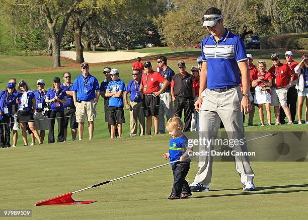 Justin Rose of England and the Lake Nona Team is amazed and his 13 month old son Leo enjoying playing with the flagstick at the at the 18th hole...