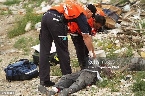 Medical personnel inspect a bullet-ridden body on March 23, 2010 in Juarez, Mexico. Secretary of State Hillary Rodham Clinton, Defense Secretary...