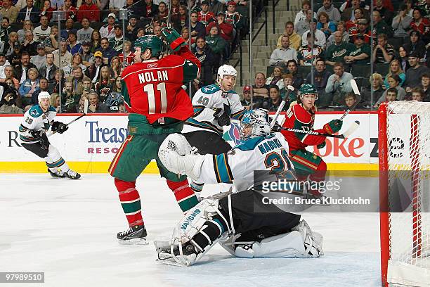 Evgeni Nabokov of the San Jose Sharks makes a glove save while being screened by Owen Nolan of the Minnesota Wild during the game at the Xcel Energy...