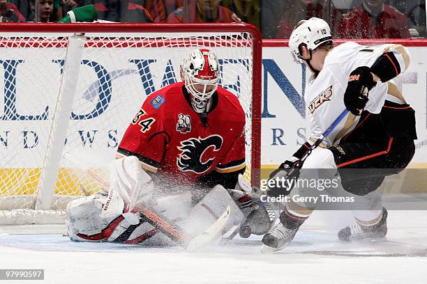 Miikka Kiprusoff of the Calgary Flames makes a save against Corey Perry of the Anaheim Ducks on March 23, 2010 at Pengrowth Saddledome in Calgary,...