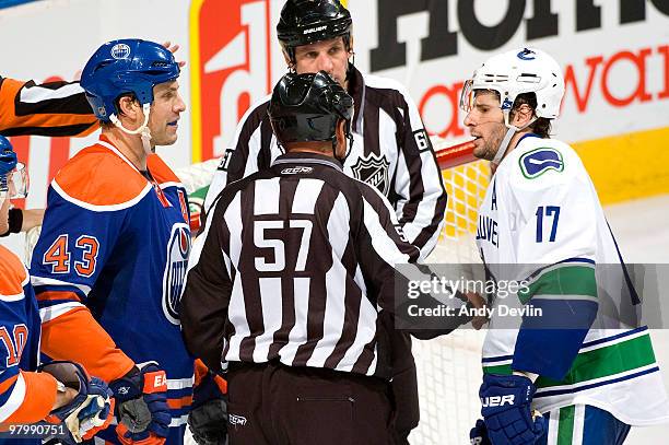 Referee separates Jason Strudwick of the Edmonton Oilers and Ryan Kesler of the Vancouver Canucks at Rexall Place on March 23, 2010 in Edmonton,...