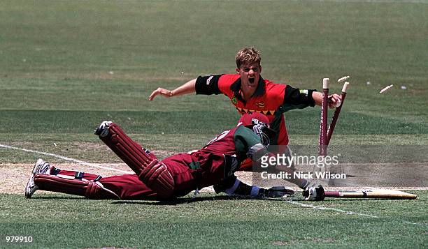 Bryan Strang of Zimbabwe runs out Daren Ganga of the West Indies for six during the Carlton Series One Day International between West Indies and...